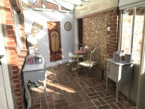 a room with a brick wall and a table and chair at Angel Cottage Cozy Nook in Boxgrove