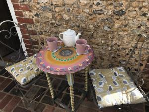 a table with a tea pot and cups on it at Angel Cottage Cozy Nook in Boxgrove