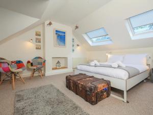 a bedroom with a bed with a suitcase on the floor at Old Villa, Cottage in Dartmouth in Dartmouth
