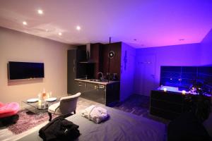 um quarto roxo com uma cama e uma cozinha em Le Purple YourHostHelper em Allevard