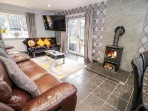 a living room with a couch and a fireplace at Meadow View in Benllech