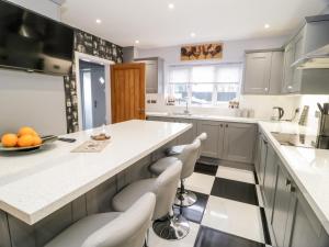 a kitchen with a large island with white counter tops at Meadow View in Benllech