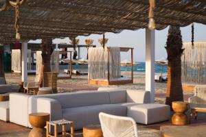 a living room with a couch and chairs on the beach at Ramlah Resort Qatar in Mesaieed