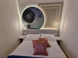 una piccola camera da letto con un letto con un cuscino sopra di Hotel Angelini a Rimini