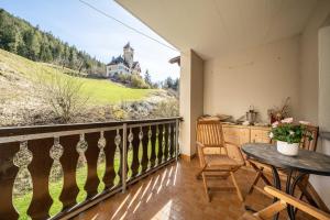 balcón con mesa y vistas a una casa en 2205 Schoen eingerichtete Wohnung mit stilvollem Flair, en Vulpera