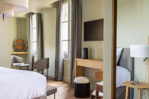 a hotel room with a bed and a table and chairs at Hotel Porte Brunet in Saint-Émilion