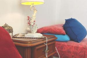 una lampada su un tavolo accanto a un letto di B&B Homme Blanche a Milis