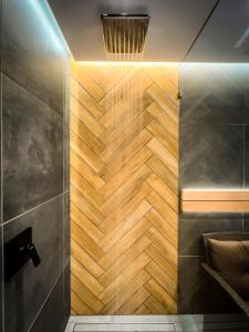 y baño con ducha y pared de madera. en Templomvölgy Resort Mátrakeresztes en Matrakeresztes