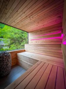 una sauna con una gran ventana y suelo de madera en Templomvölgy Resort Mátrakeresztes, en Matrakeresztes