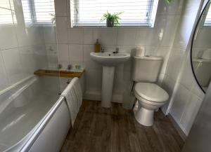 a bathroom with a toilet and a sink and a tub at #1 Limes by DerBnB, Modern 1 Bedroom Apartment, Free Parking, WI-FI & Netflix Near Royal Derby Hospital in Derby