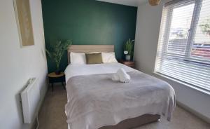 a bedroom with a bed with a stuffed animal on it at #1 Limes by DerBnB, Modern 1 Bedroom Apartment, Free Parking, WI-FI & Netflix Near Royal Derby Hospital in Derby