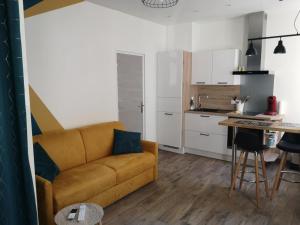 a living room with a couch and a kitchen at Haute ville : studio ravissant in Granville