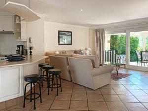 a kitchen and living room with a couch and a table at River Club 4213 in Plettenberg Bay