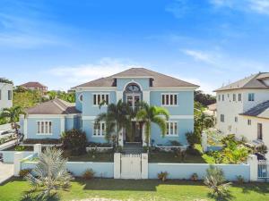 a large blue house with a white fence at Blu Diamond Luxury Estate Home in Nassau
