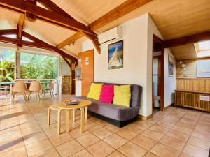 a living room with a couch and a table at Villa Patio + jacuzzi, FREE Surf+Body+Sup in Capbreton