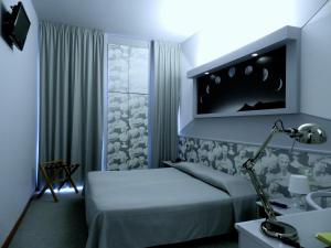 Hotel Italia في ستراديلا: غرفة نوم مع سرير وتلفزيون على الحائط
