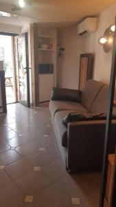 a living room with a couch and a kitchen at LE PAILLER 2P et 3 enfants sous le tipi in Calvi