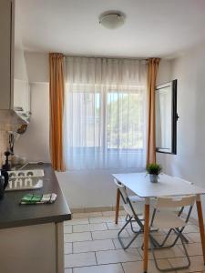 a kitchen with a table in front of a window at Apartments Mitende in Budva