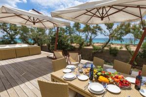 トッレ・ラピッロにあるVilla Bianca by Perle di Pugliaの海の景色を望むデッキに木製テーブルと食べ物