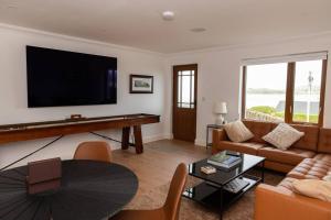 a living room with a large flat screen tv at Rosapenna Golf Cottage, Donegal, Ireland in Downings