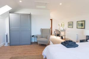 una camera da letto con due letti, una sedia e una scrivania di Rosapenna Golf Cottage, Donegal, Ireland a Downings