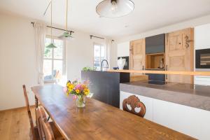 a kitchen with a wooden table with a vase of flowers on it at das schulhaus in Enzklösterle