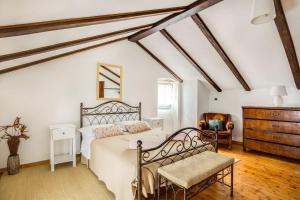 a bedroom with a bed and a chair and a dresser at Rustic villa Casa Mazuli with pool in Groznjan in Grožnjan +36 photos