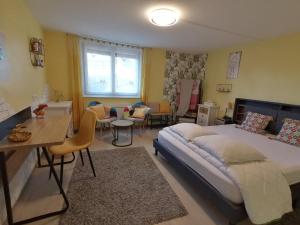 1 dormitorio con 1 cama, mesa y sillas en Chambres d'Hôtes de l'Avison, en Bruyères