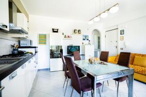 una cucina e una sala da pranzo con tavolo e sedie di House Seagull a Mascali