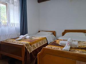 twee bedden in een kamer met handdoeken erop bij Guesthouse Te Tata in Theth