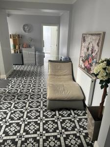 a living room with a couch on a tile floor at Chi Lodge & Accommodation in Rainham