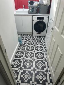 a bathroom with a washer and dryer on a tile floor at Chi Lodge & Accommodation in Rainham