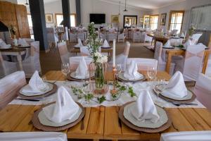 a dining room with a table with white napkins and chairs at Goshen Guest Farm in Edenburg