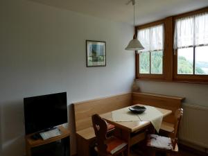 a small dining room with a table and a television at Ferienwohnungen Ringlihof in Horben