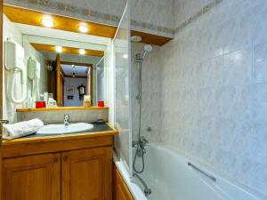 a bathroom with a tub and a sink and a mirror at Appartement Val-d'Isère, 3 pièces, 4 personnes - FR-1-694-201 in Val-d'Isère