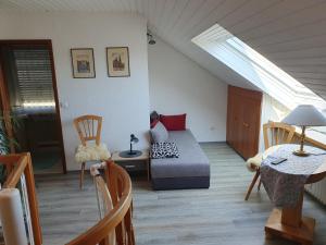 a living room with a bed and a skylight at Galerie-Apartment in Wendelstein