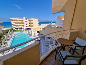 a balcony with a view of a pool and the ocean at Sunny Bay Hotel in Kissamos