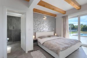 a bedroom with a large bed and a bathroom at Villa Civitan with infinity pool in Novigrad in Nova Vas +32 photos