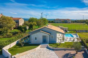 an aerial view of a house with a swimming pool at Villa Civitan with infinity pool in Novigrad in Nova Vas