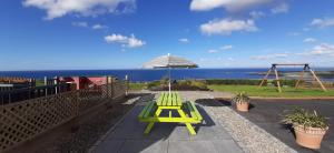 un patio con banco, sombrilla y columpio en Sea Breeze, en Doolin