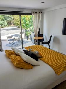 Una cama con una manta amarilla encima. en Chambre dans Villa proche Rennes - Cuisine, Entrée indépendante, en Laillé