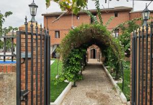 an entrance to a building with an arch covered in ivy at Teralba 1 Casa Rural in La Calzada de Oropesa