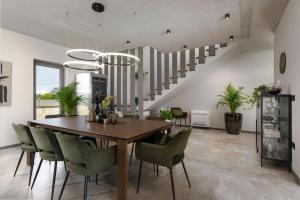 a dining room with a wooden table and green chairs at Luxury Villa Lipa Tree with pool in Novigrad in Novigrad Istria