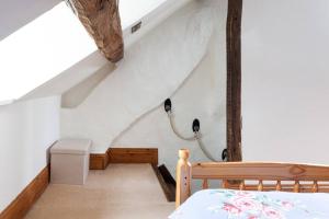 Habitación en el ático con cama y escalera en Cosy Cotswolds cottage with strong WiFi and self check in service, en Gloucestershire
