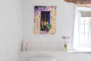 łazienka z obrazem na ścianie nad toaletą w obiekcie Cosy Cotswolds cottage with strong WiFi and self check in service 