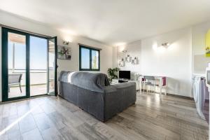 a living room with a gray couch and a kitchen at Apartamento Las Vistas in Mijas