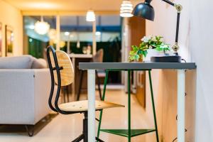 a table with a lamp and a chair in a room at Trendy La Roma Condo with Parking & Patio in Mexico City +148 photos