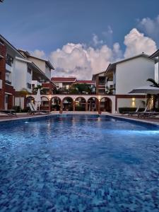 ein großer Pool vor einigen Gebäuden in der Unterkunft SEVEN SHADES OF CORAL VILLAGE - suites & pool in a residence close to the beach in Punta Cana