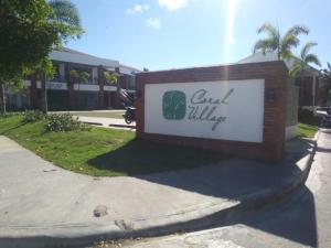 ein Schild für ein Hotel vor einem Gebäude in der Unterkunft SEVEN SHADES OF CORAL VILLAGE - suites & pool in a residence close to the beach in Punta Cana