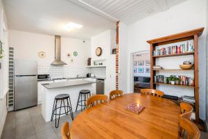 eine Küche und ein Esszimmer mit einem Holztisch und Stühlen in der Unterkunft Captain's Heritage Cottage - central Fremantle 2 bedroom historic cottage in Fremantle